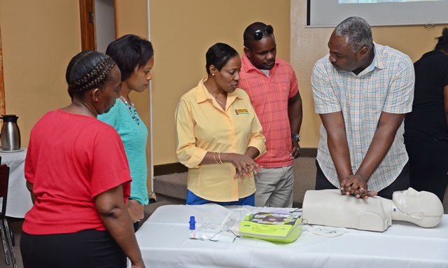 Nurse Sharon Thompson instructing part of the group in administering CPR