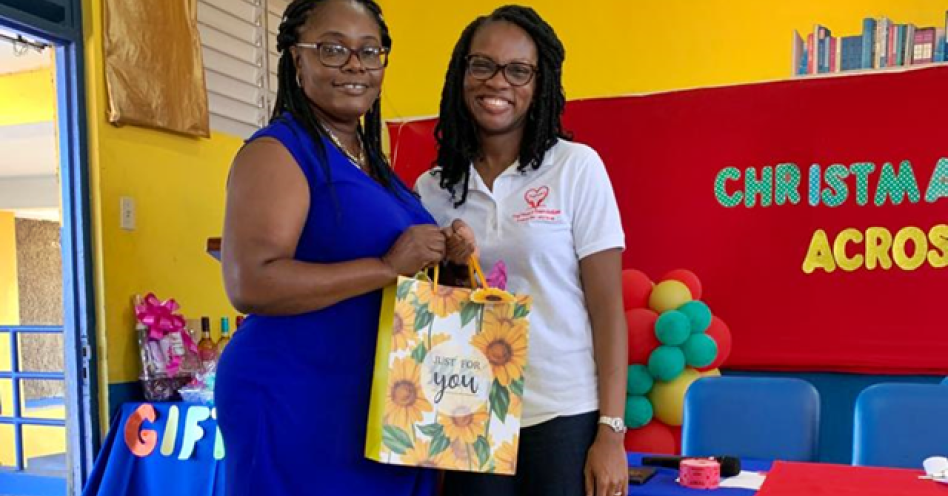 Dr Odette Thomas (right) makes a presentation to a teacher at Old Harbour Primary School.