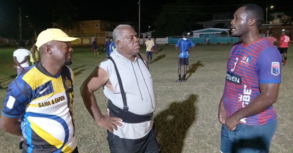 Coaches Jermaine Douglas (left) and Bill Martin (centre) locked in a conversation with Andre Dyce during training at the Old Harbour Glades Community Playfield. (OH News Photo)